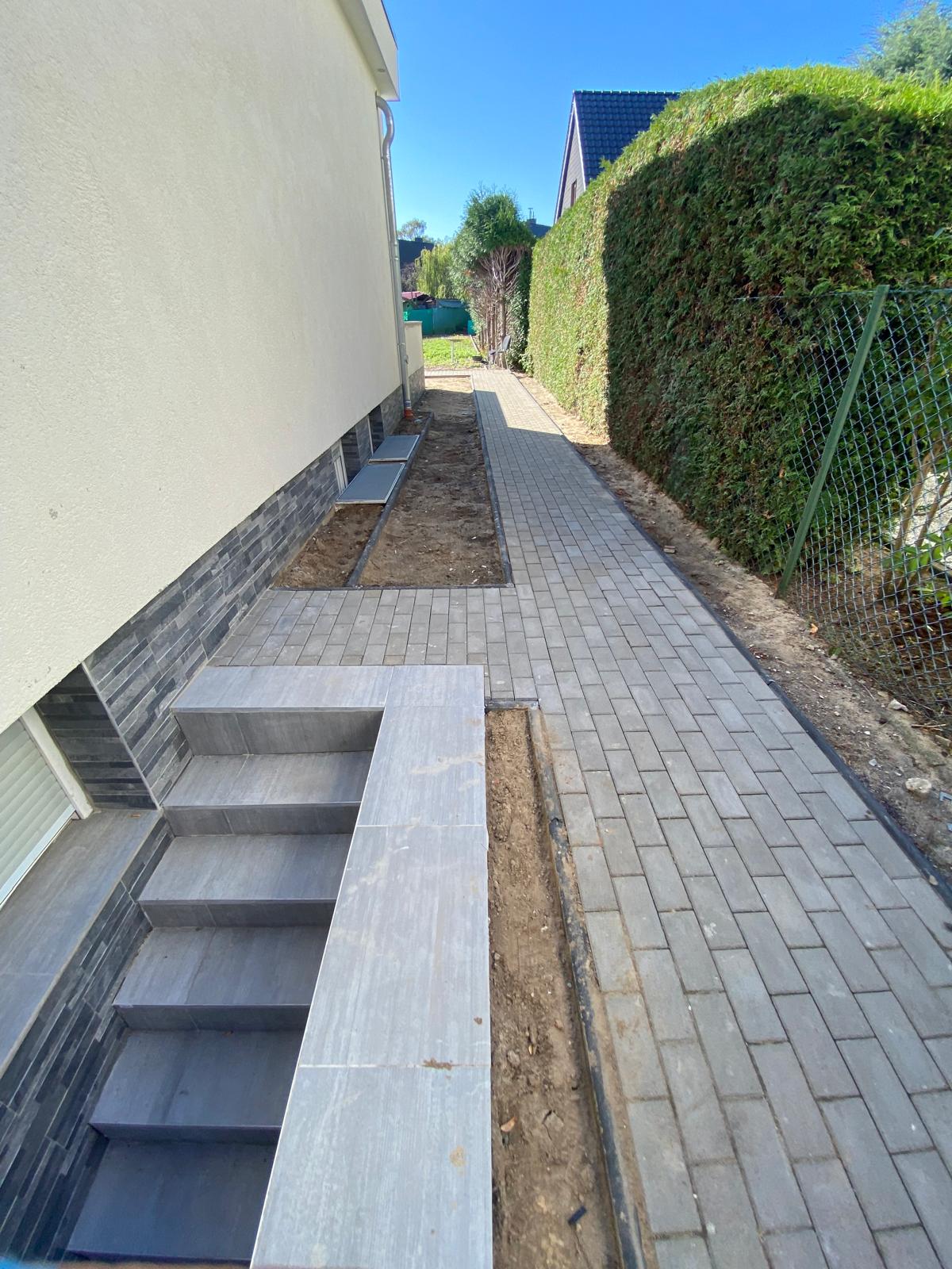 Seitlicher Pflasterweg mit Treppe