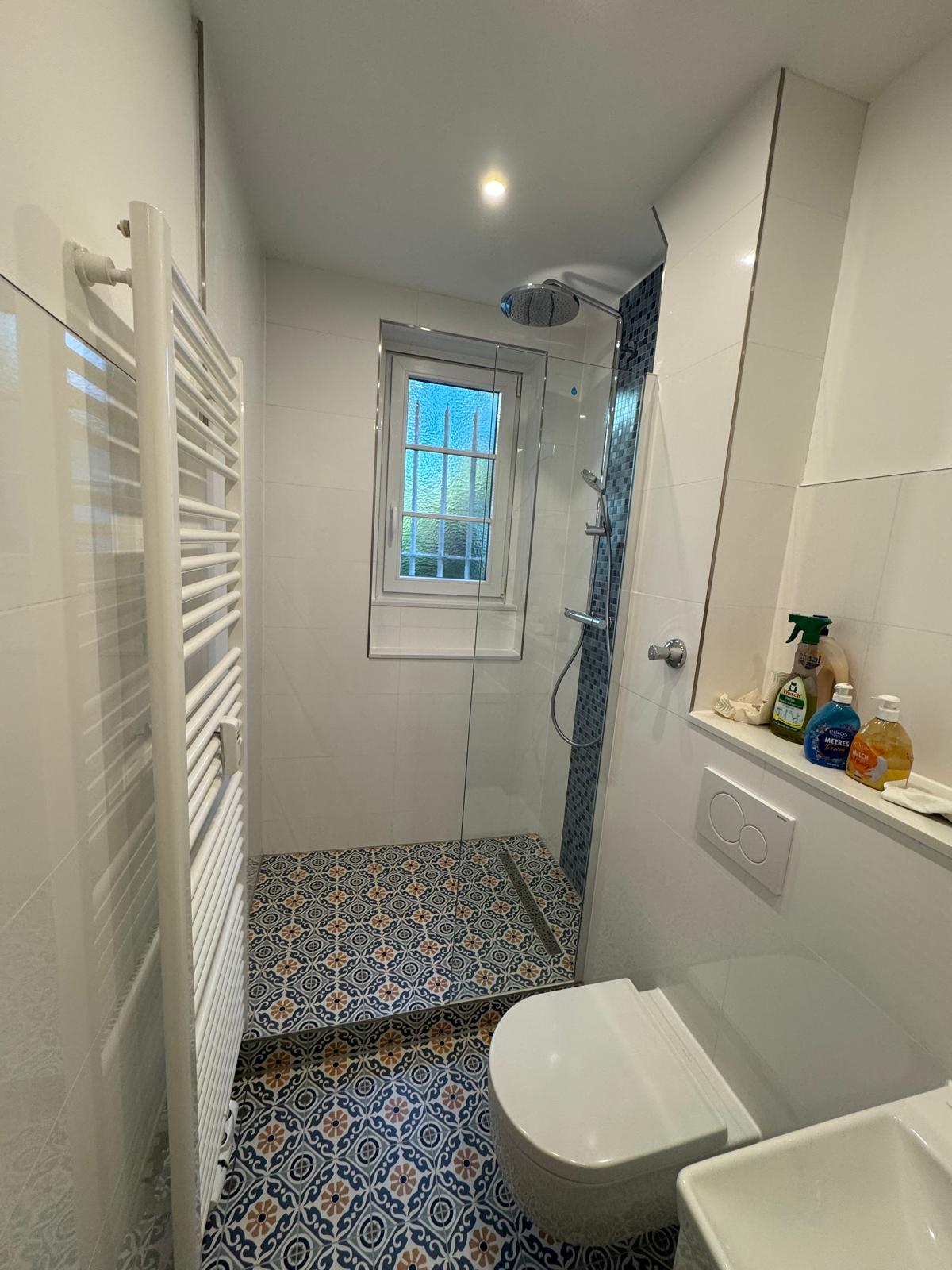 Badezimmer mit Dusche und Handtuchheizkörper